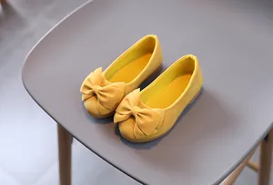 Vista dall'alto di ballerine gialle per bambine con grande fiocco decorativo