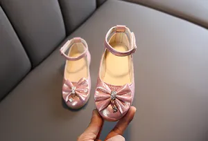 Close-up of pink glitter Mary Jane shoes for girls with rhinestone bow and ankle strap