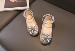 Dettaglio scarpe da principessa per bambina metallizzate con grande fiocco e strass