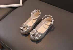 Dettaglio scarpe neonata color argento champagne con paillettes e fiocco lucido