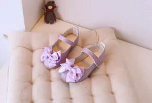 Detail of purple glitter Mary Jane shoes with large satin bow and scalloped trim edge