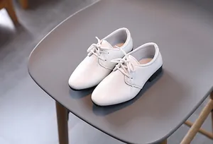 Nahaufnahme weißer strukturierter Derby-Schuhe für Jungen mit schwarzer Sohle
