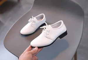 Details von weißen Oxford-Schuhen für Jungen mit Lederstruktur und schwarzer Gummisohle