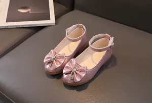 Dettaglio di scarpe da principessa rosa con paillettes e fiocco di strass per bambine