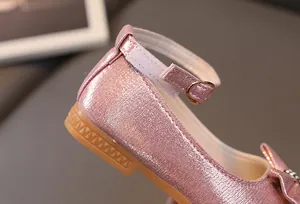 Dettaglio di scarpe da principessa rosa con fibbia regolabile e glitter fine