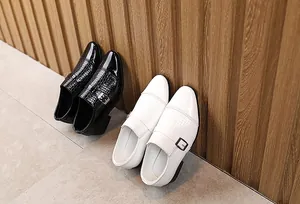 Detail of boys dress shoes featuring woven texture and glossy patent leather toe