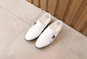 Dettaglio di scarpe formali da bambino bianche con fibbia in metallo e borchie