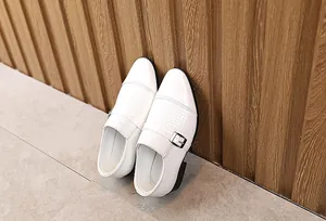 Detail of boys white monk strap leather shoe with woven texture and silver buckle
