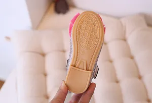 Macro shot of non-slip rubber sole with geometric pattern and pink bow on kids shoe