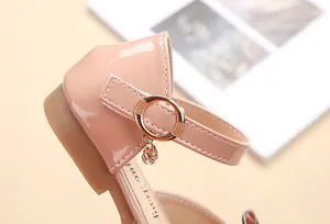 Dettaglio di ballerine rosa in vernice per bambina con fibbia dorata e ciondolo di cristallo