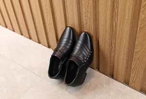Dettaglio scarpe eleganti nere da bambino con borchie metalliche e texture a righe