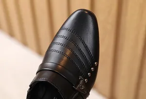 Dettaglio macro di scarpa in pelle nera da bambino con cuciture fini e fibbia argento