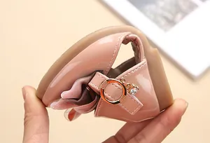 Dettaglio di scarpe flessibili in vernice rosa da bambina con suola in gomma pieghevole