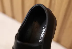 Dettaglio macro dell'interno del tallone e del logo argentato della scarpa elegante