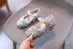 Dettaglio di scarpe Mary Jane argento con paillettes e cinturino di perle da bambina
