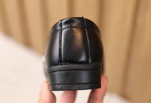 Dettaglio delle cuciture doppie rinforzate e suola spessa su scarpe in pelle da ragazzo