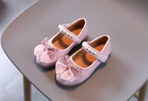 Détail de ballerines roses à paillettes pour filles avec nœud en dentelle et perles