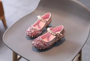 Dettaglio ravvicinato delle scarpe Mary Jane rosa glitterate con cinturino di perle