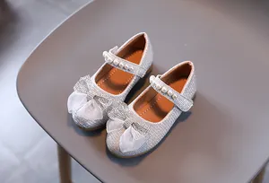 Détail de ballerines argentées pour filles avec gros nœud en tulle et bride perlée