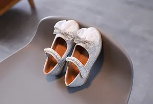 Détail de chaussures princesse pailletées argent avec nœud organza et perles