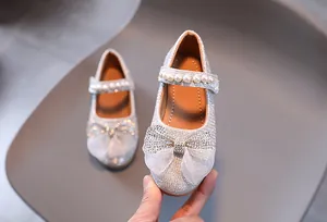 Détail de ballerines Mary Jane pailletées argent avec nœud organza et perles