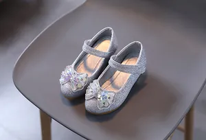 Dettaglio ravvicinato delle scarpe Mary Jane argento con glitter, fiocco e perle