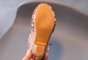 Dettaglio della suola in gomma antiscivolo e del tacco largo della scarpa rosa glitter