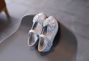 Dettaglio scarpe Mary Jane argento con paillettes, fiocco glitterato e cinturino