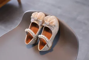 Détail de chaussures Mary Jane dorées pour filles avec nœud pailleté et perles