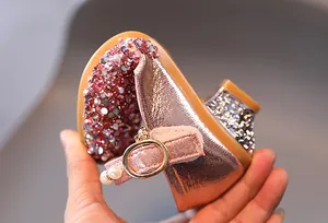 Dettaglio di scarpa flessibile per bambina in oro rosa con strass lucidi e fibbia di perle