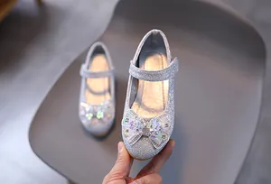 Dettaglio scarpe da principessa per bambina in paillettes argento con fiocco di cristallo