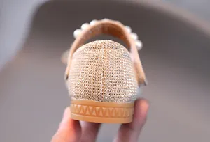 Détail de chaussures de princesse avec paillettes dorées, semelle antidérapante et perles