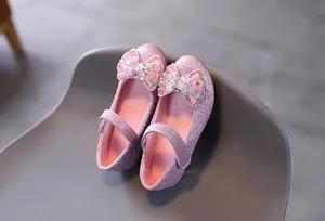 Dettaglio scarpe Mary Jane glitterate da bambina con fiocco e finitura viola brillante