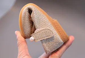 Détail de chaussures dorées pour filles avec semelle souple et bride à perles