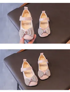 Dettaglio di scarpe Mary Jane rosa per bambina con fiocco di strass e cinturino velcro