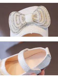 Dettaglio di scarpa Mary Jane bianca da bambina con fiocco di perle e strass