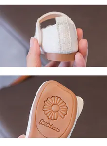 Dettaglio di ballerine bianche intrecciate per bambina con suola antiscivolo a girasole