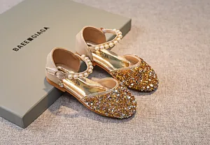 Detailansicht goldene Glitzer-Mädchenschuhe mit Kunstperlenriemen und Metallschnalle