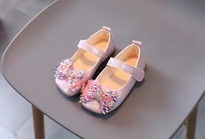 Détail de chaussures de princesse roses à paillettes pour fille avec nœud brillant