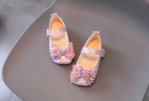 Détail du nœud rose pailleté et strass scintillants sur chaussures de princesse pour fille