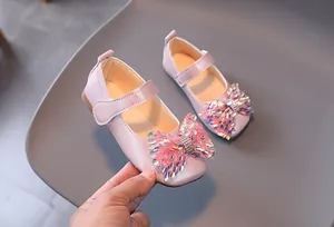 Détail de chaussures Mary Jane roses pour filles avec un nœud pailleté et strass