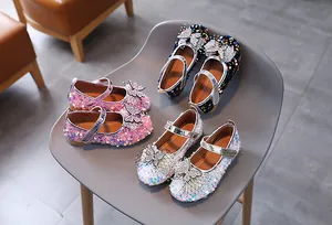 Close-up of glitter Mary Jane shoes with rhinestone bows in pink, blue, and white colors