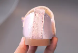 Détail de chaussures princesse roses montrant la bride du talon et le fini pailleté