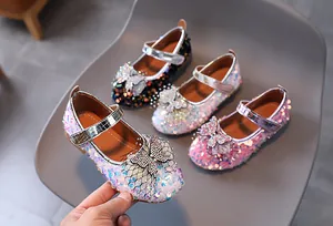 Close-up of glitter girls Mary Jane shoes with rhinestone bows in pink, silver and black