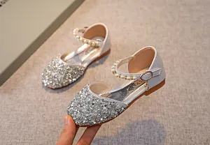 Detail von silbernen Pailletten-Prinzessinenschuhen für Mädchen mit Perlenriemen