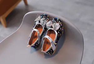 Close-up of navy blue glitter Mary Jane shoes with silver diamond bow detail