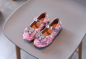 Close-up of pink sequined girls' Mary Jane shoes with rhinestone butterfly detail