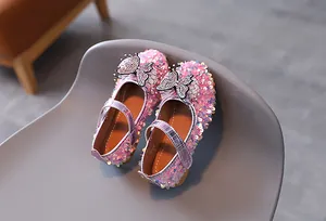 Close-up of glittery pink girls' princess shoes with rhinestone bow and velcro strap