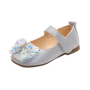 Détail de chaussures de princesse argentées avec nœud en tulle pailleté et strass