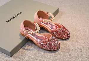 Nahaufnahme von rosa Pailletten und weißem Perlenriemen an Mary Jane Prinzessinnen-Schuhen